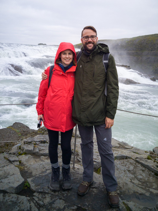 Couple standing near a waterfall