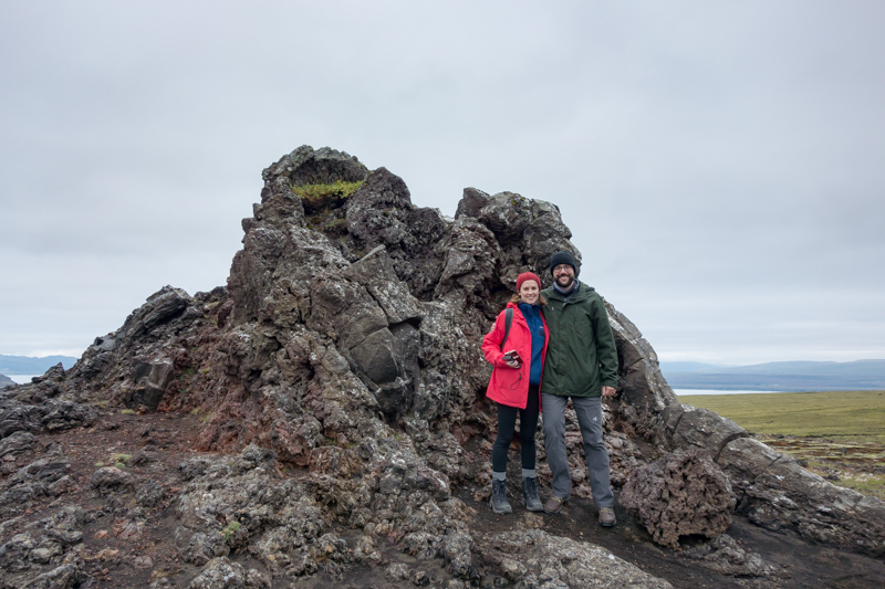 A couple standing next to a lava formation in Iceland