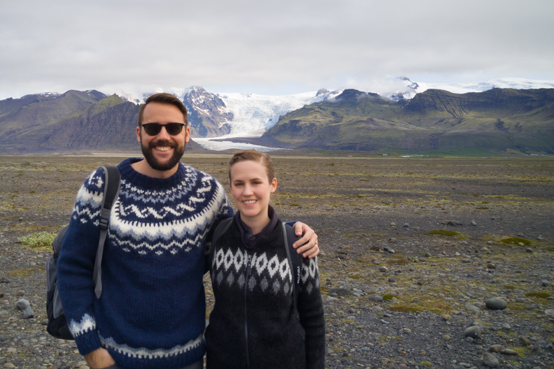 A couple with a large glacier in the distance