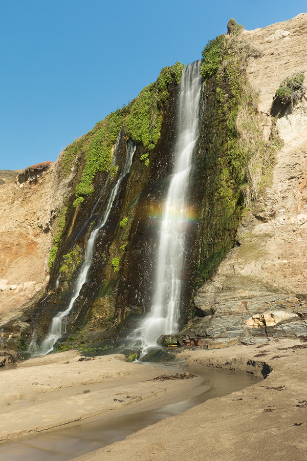 beach waterfall with rainbow